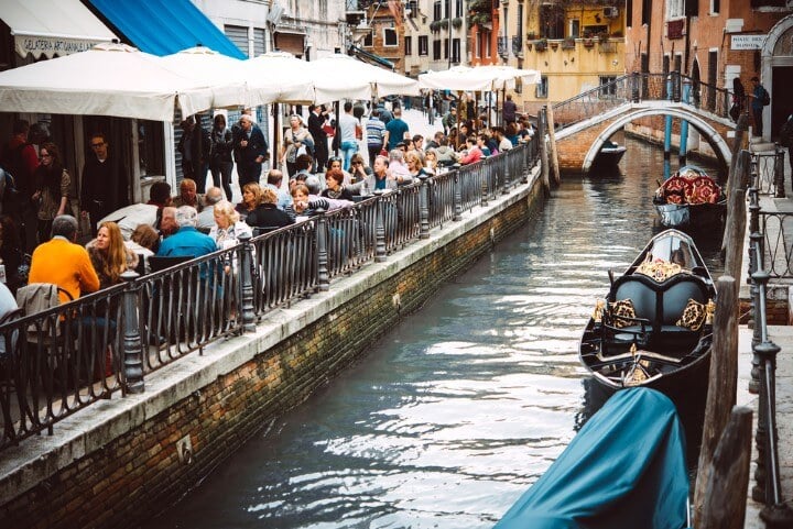 Bares en los canales de Venecia con gente sentada