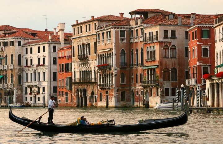 Canal veneciano con una góndola navegando