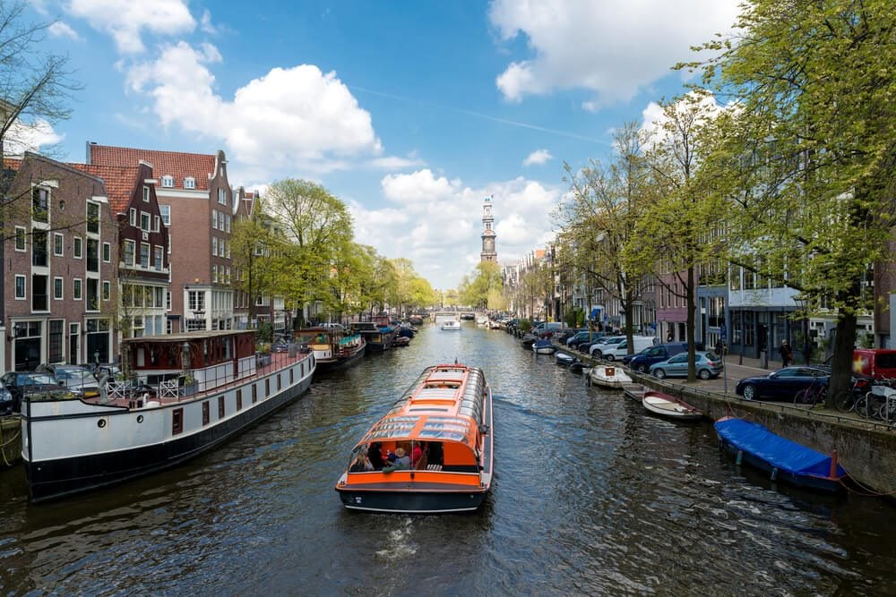 Barco turístico surca uno de los canales de Ámsterdam en los Países Bajos