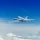 Un avión vuela sobre las nubes en un cielo azul