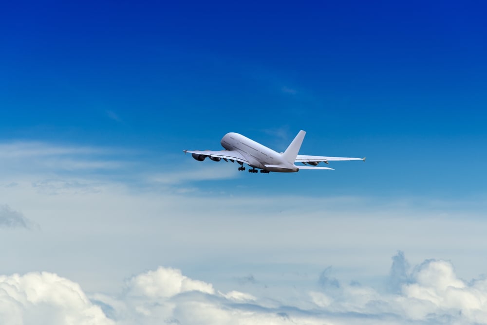 Un avión vuela sobre las nubes en un cielo azul