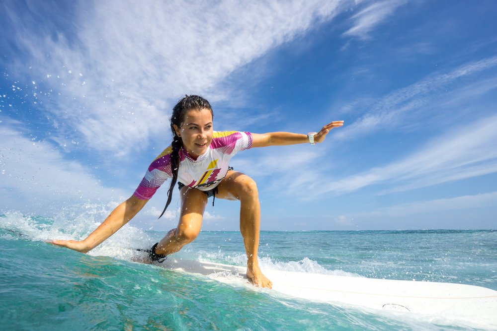 Mujer practicando surf en las costas de Benidorm.
