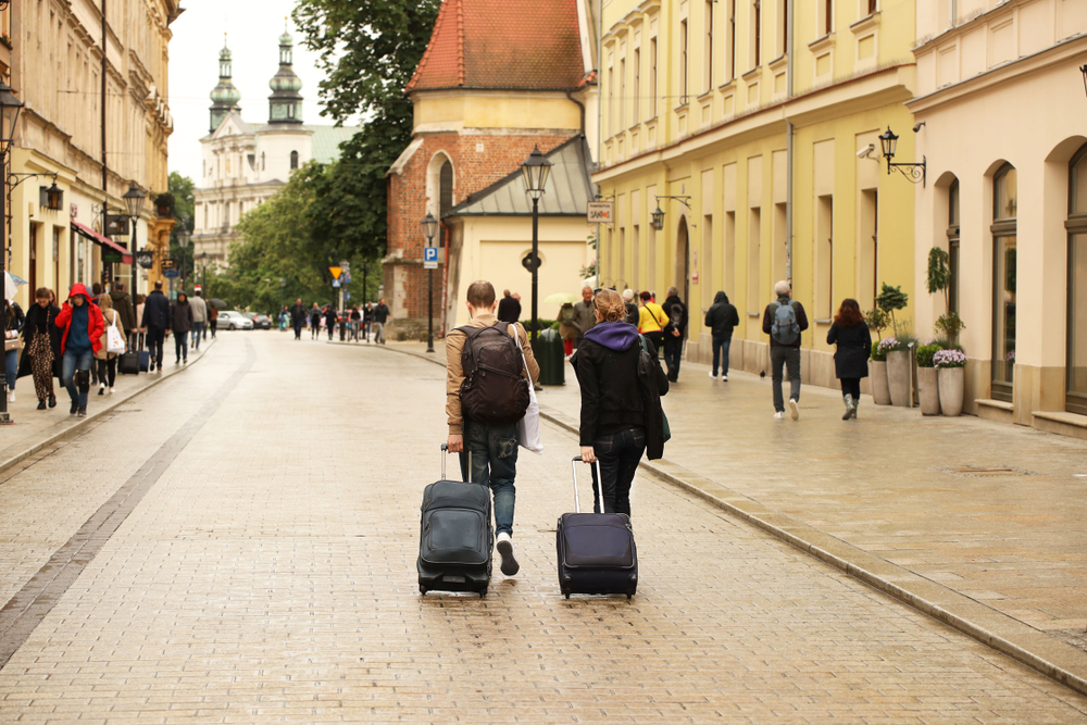 Dos turistas con maletas caminan por una de las calles del casco antiguo de Cracovia, Polonia.