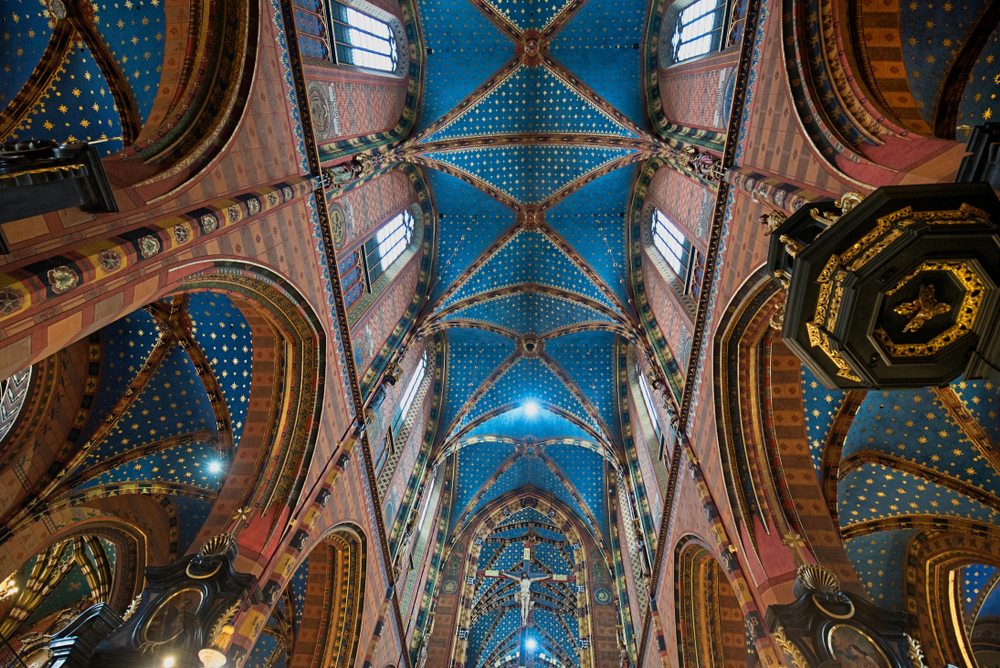 Interior de la Basílica de Santa María de Cracovia con sus arcos y columnas decorados con vivos colores.