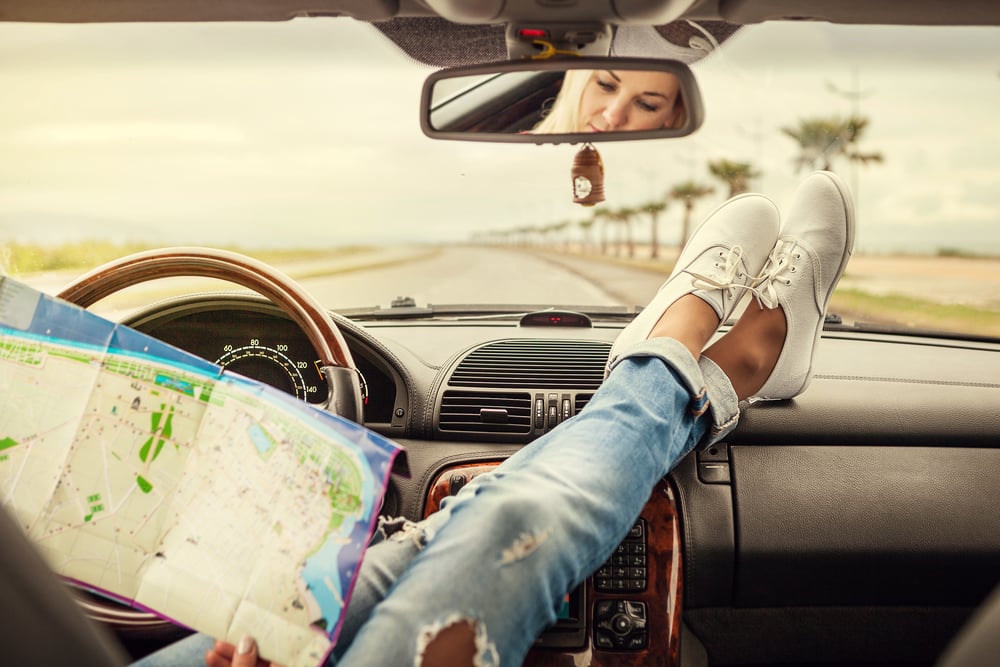 joven viajera en coche con mapa