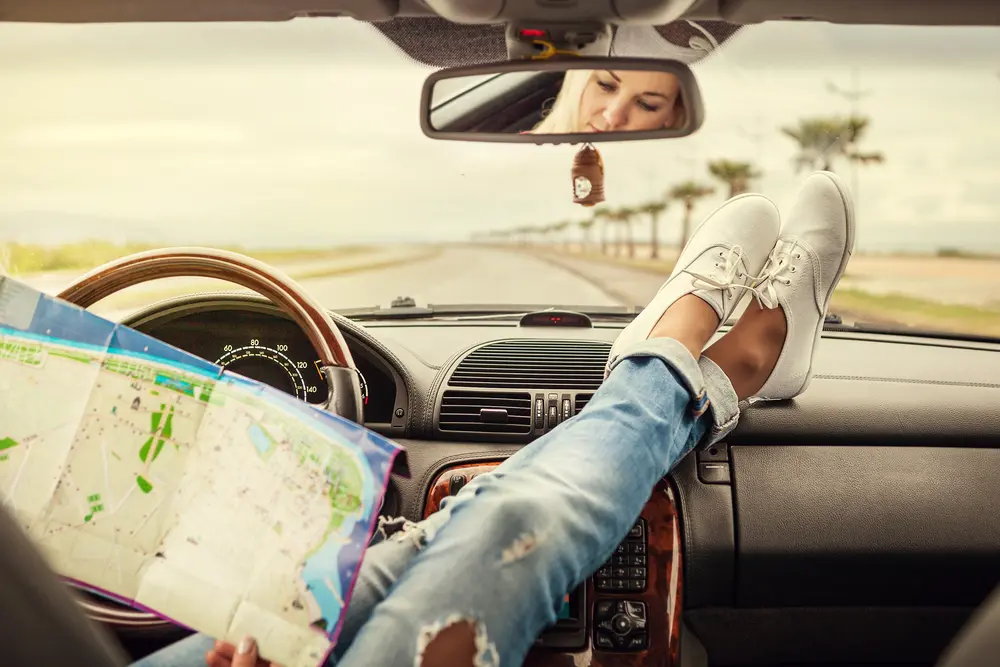 joven viajera en coche con mapa