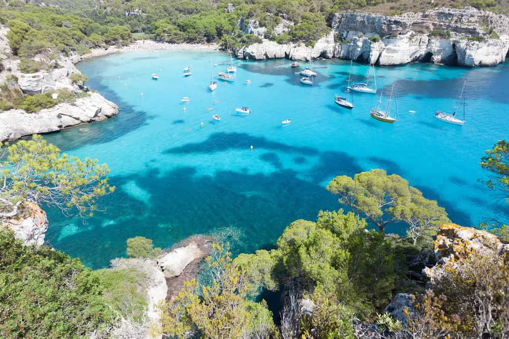 Vista aérea de la Cala Macarella con barcos y yates en Menorca