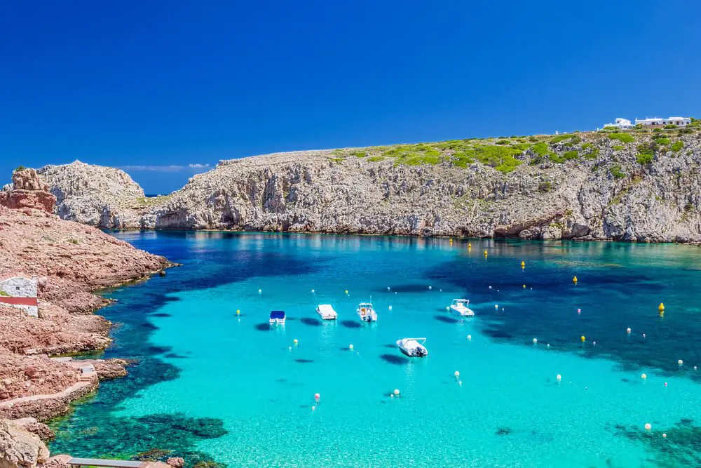 Cala Morell rodeada de acantilado rocoso en Menorca, Baleares