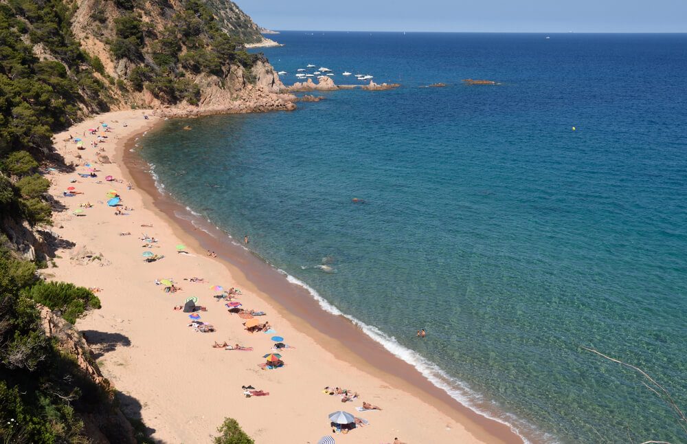 Bañistas en el arenal de la cala del Senyor Ramon en Santa Cristina d'Aro, Costa Brava