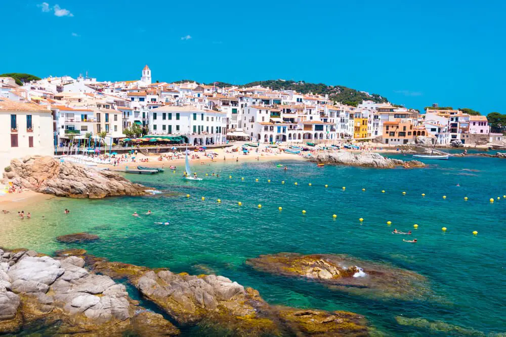Casas blancas del casco de Calella de Palafrugell con la Platja del Port Po delante, en Girona
