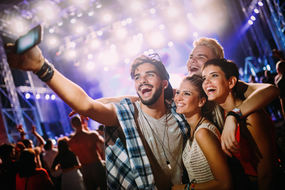Felices amigos se toman selfie en el festival de música