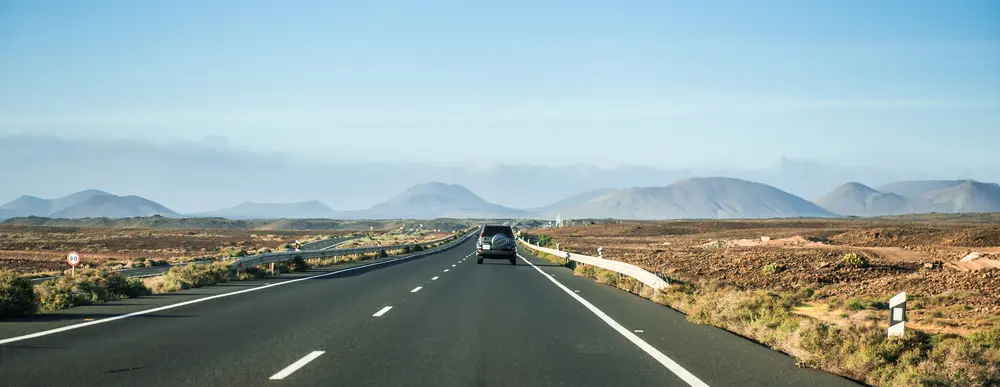 coche conduciendo hacia las montañas en el desierto de Canarias, Lanzarote