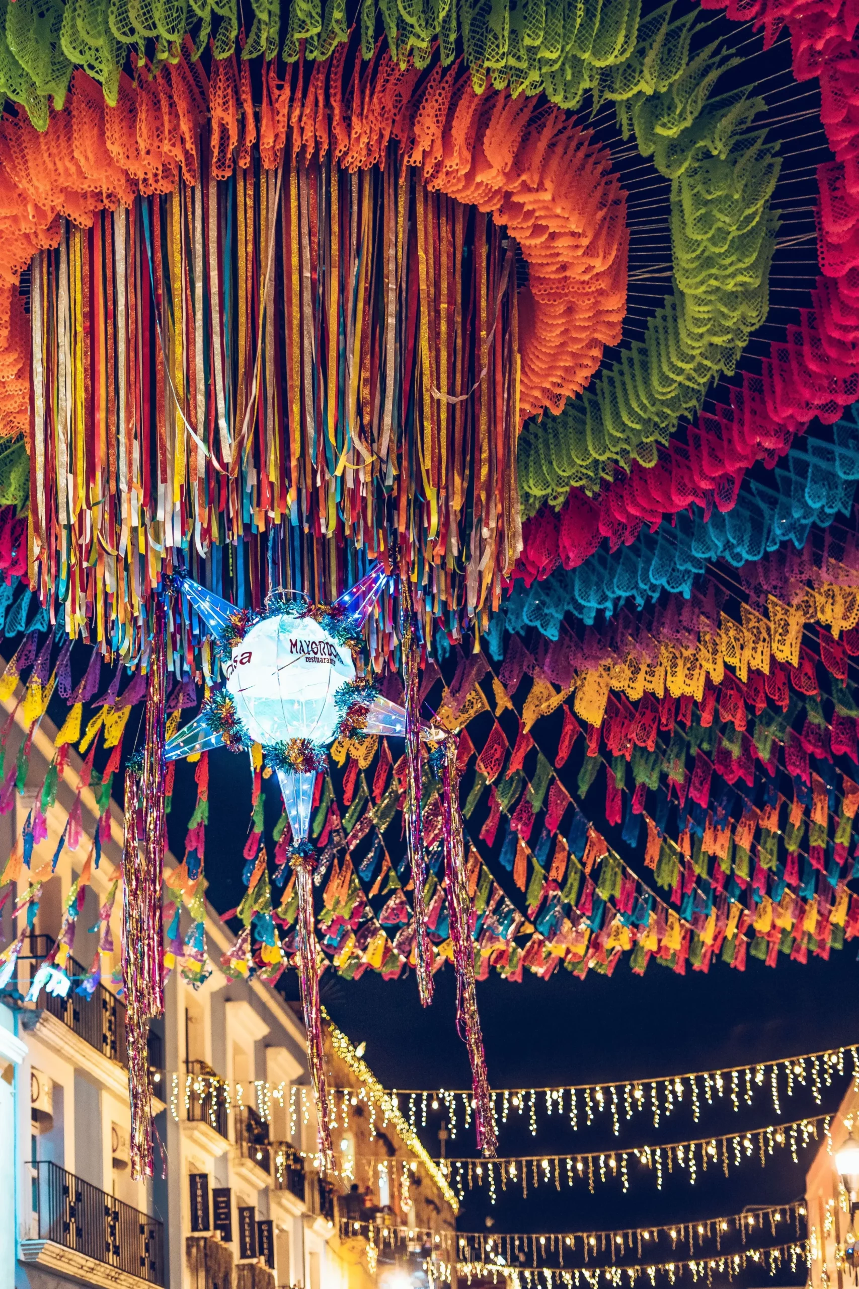 Calle decorada para la celebración de Las Posadas en México con piñatas, luces navideñas y adornos festivos de colores